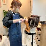 ウィッグを仕上げる美容師