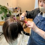 ウィッグを仕上げている美容師