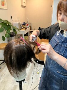 ウィッグを仕上げている美容師