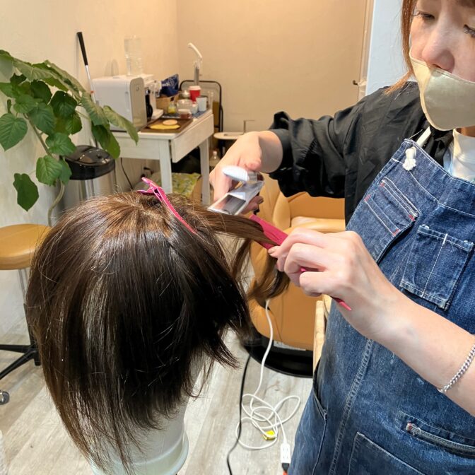 ウィッグを仕上げている美容師